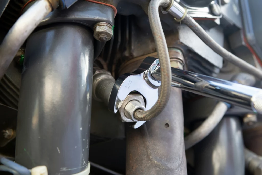 A worker uses a wrench to repair a hydraulic pump