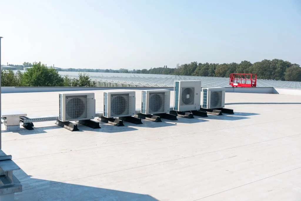 Multiple outdoor heat pump condenser units installed on a rooftop, used for commercial heating and cooling systems