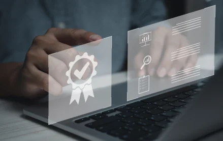Person using a laptop with digital certification and audit icons, illustrating MPC’s CMMC Level 2 certification for protecting sensitive defense information.